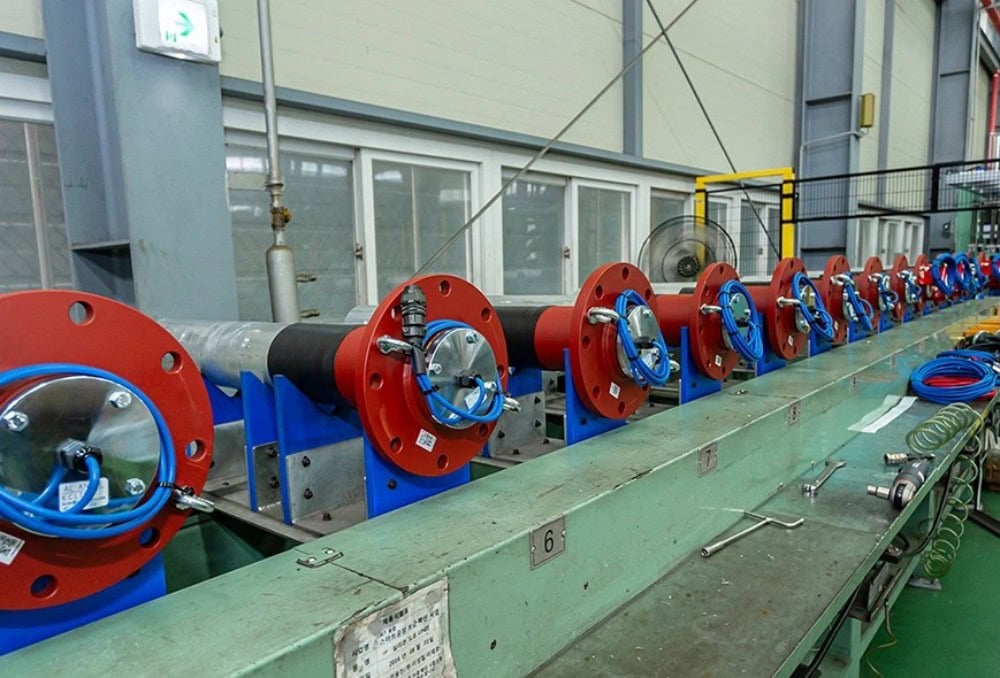 High voltage coil manufacturing setup with insulated wiring and mounting fixtures for industrial electrical applications.