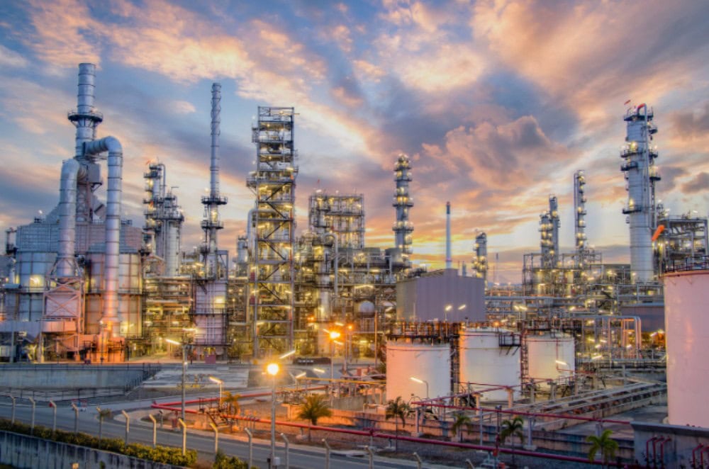 Refinery industrial plant with distillation towers, pipelines, and processing units in a large-scale petrochemical facility.